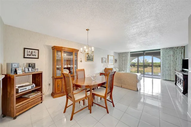 a dining room with furniture and a floor to ceiling window