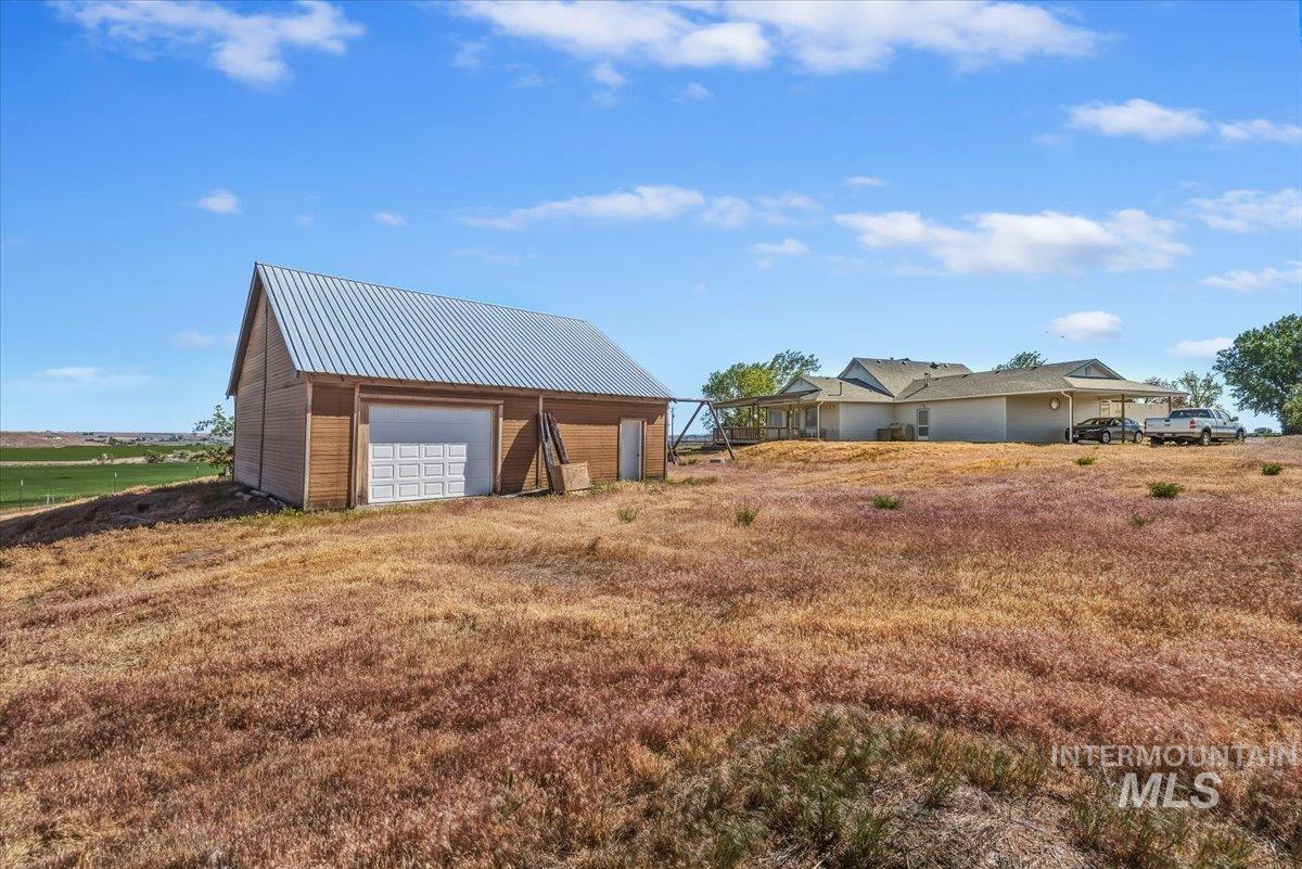 2331 Gulley Road Homedale, ID 83628 - Photo 46 of 46 Property featuring a detached barn with a metal roof and garage door, and a single-story residence with a covered patio and carport