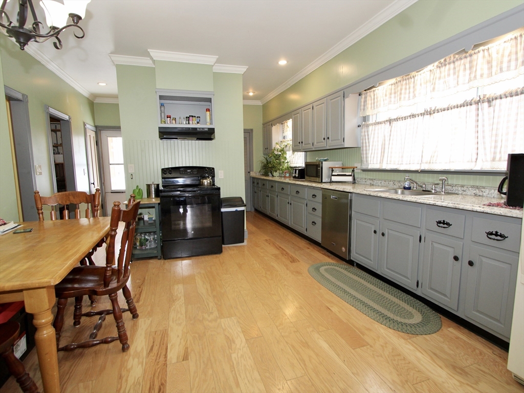 18 South Stowell Street Worcester, MA 01604 - Photo 2 of 16 a kitchen with granite countertop a stove a sink a dining table and chairs