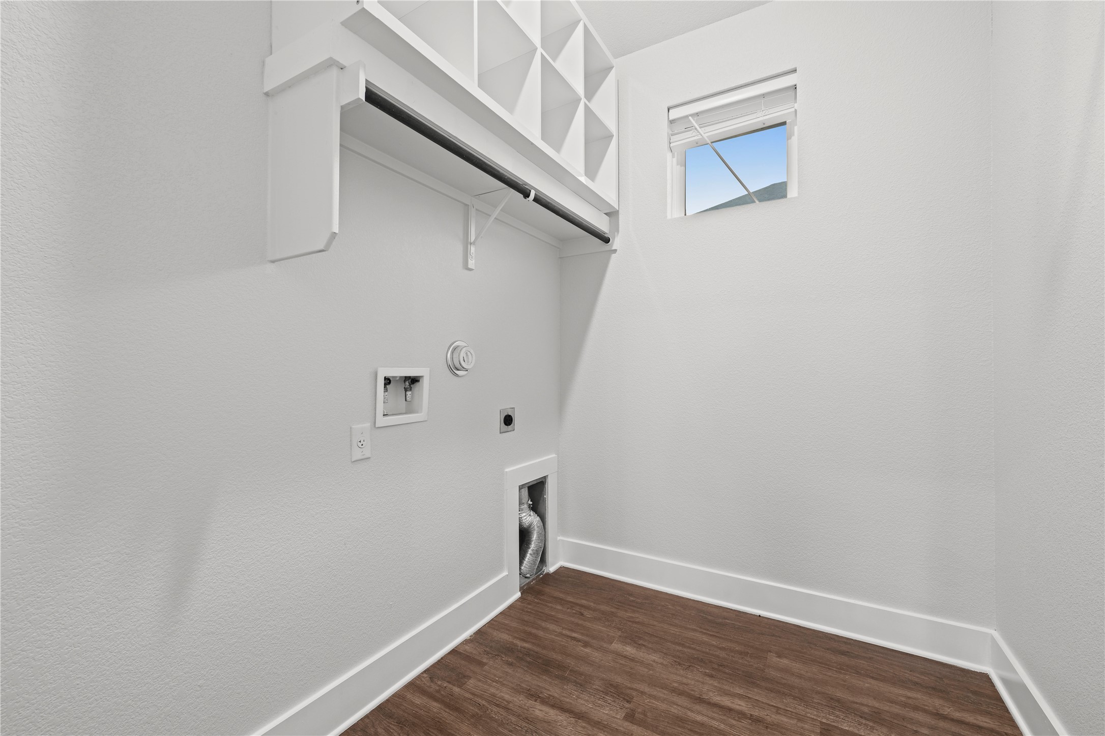 60 Rancho Trail Georgetown, TX 78628 - Photo 24 of 36 An efficient utility space features rich wood-look flooring and built-in upper shelving above laundry hookups.