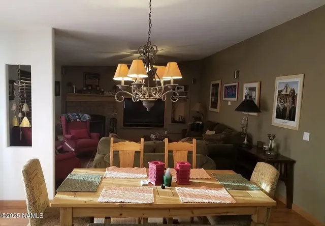 a view of a dining room with furniture a chandelier and wooden floor