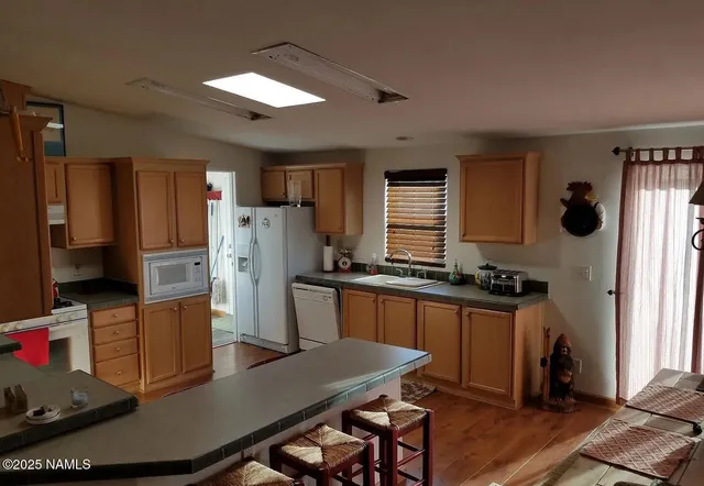 a kitchen with stainless steel appliances a stove a refrigerator a sink a dining table and chairs