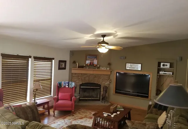 a living room with furniture a fireplace and a flat screen tv