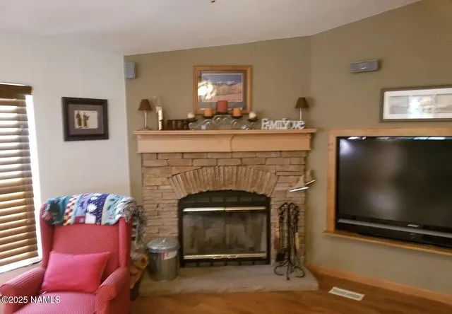 a living room with furniture a flat screen tv and a fireplace
