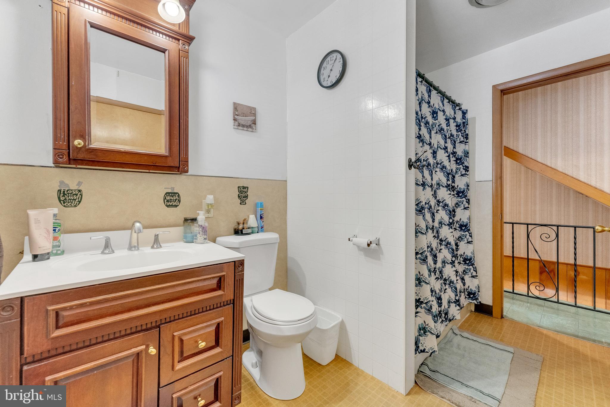 152 Division Street Trenton, NJ 08611 - Photo 18 of 24 a bathroom with a sink a toilet and shower curtain