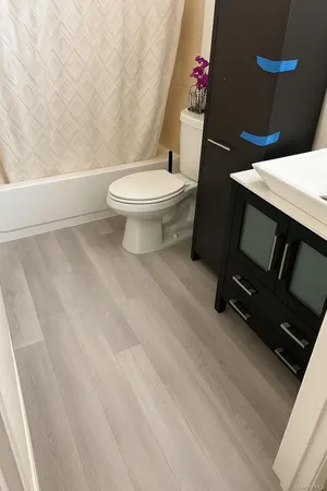 a white toilet sitting next to a white tub