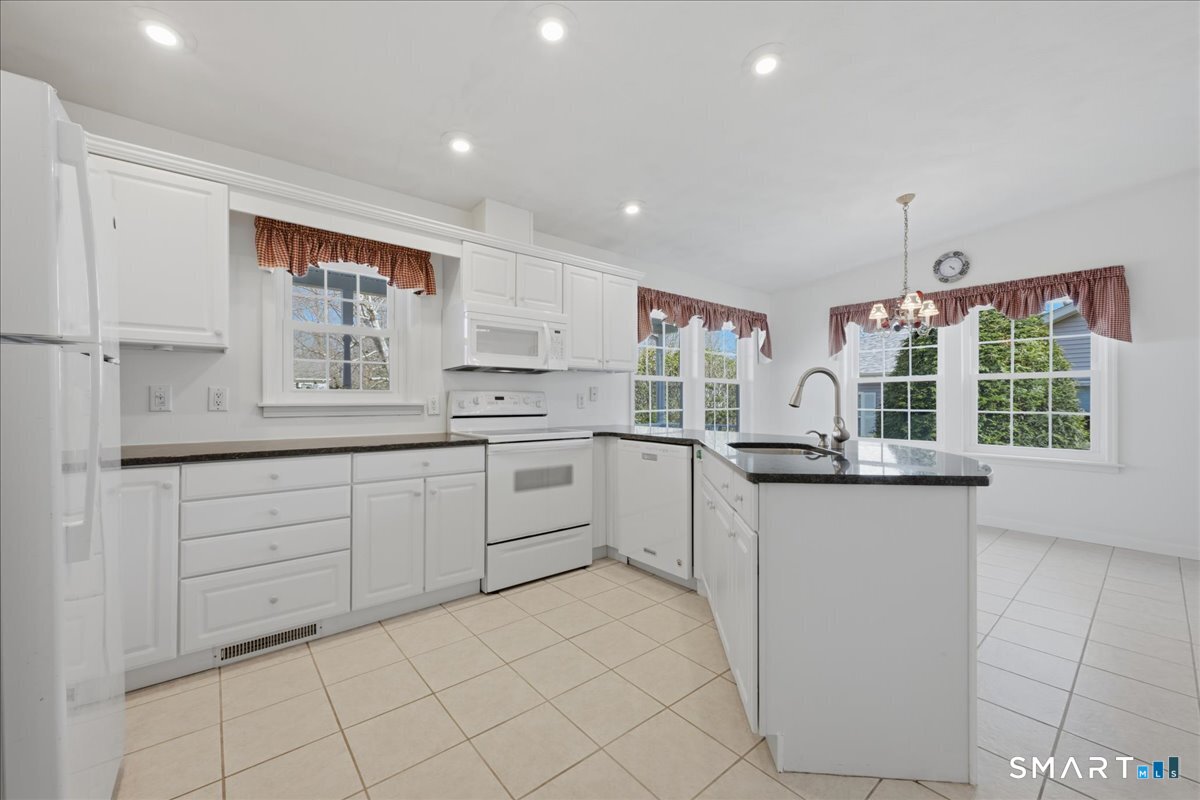 25 Heather Brook Road Montville, CT 06382 - Photo 17 of 39 a kitchen with white cabinets and white appliances