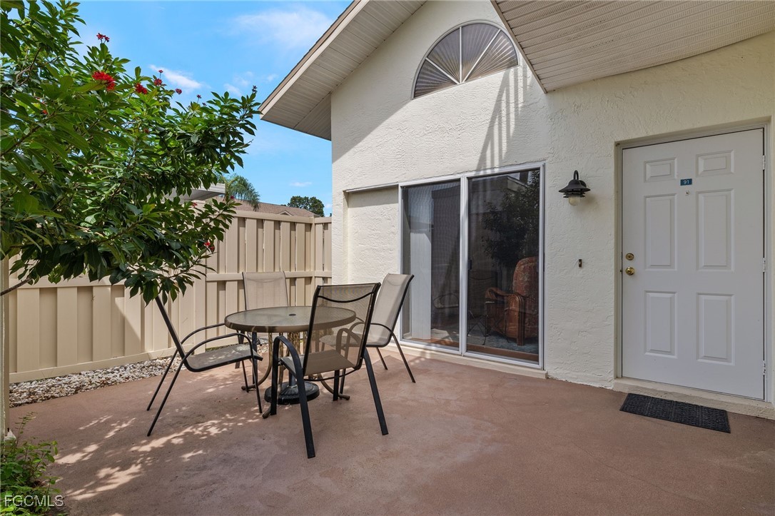 6891 Pentland Way, Unit 91 Fort Myers, FL 33966 - Photo 32 of 33 a patio with table and chairs and potted plants