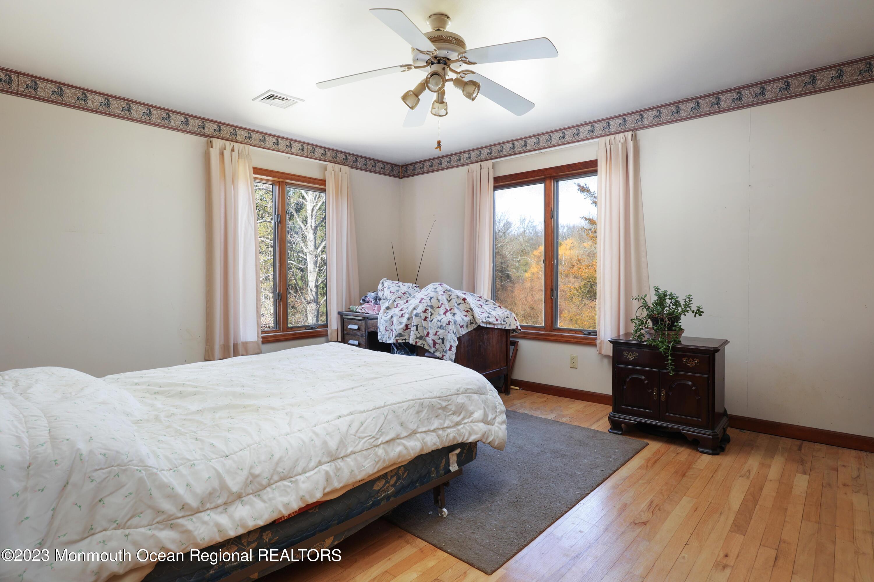 25 Meirs Road Cream Ridge, NJ 08514 - Photo 13 of 17 a bedroom with a large bed and a chandelier