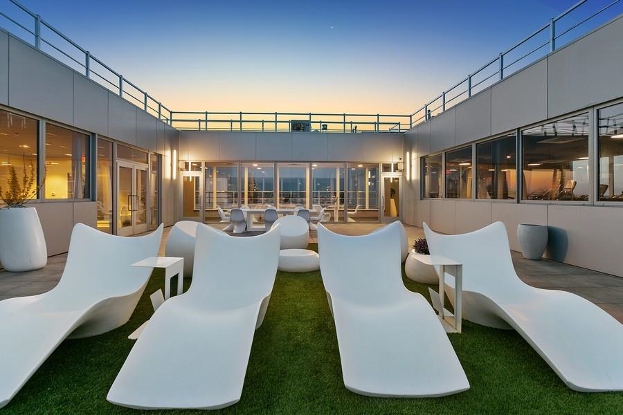 477 Broadway, Unit 409 Bayonne, NJ 07002 - Photo 11 of 19 a view of a patio with couches dining table and chairs with wooden floor