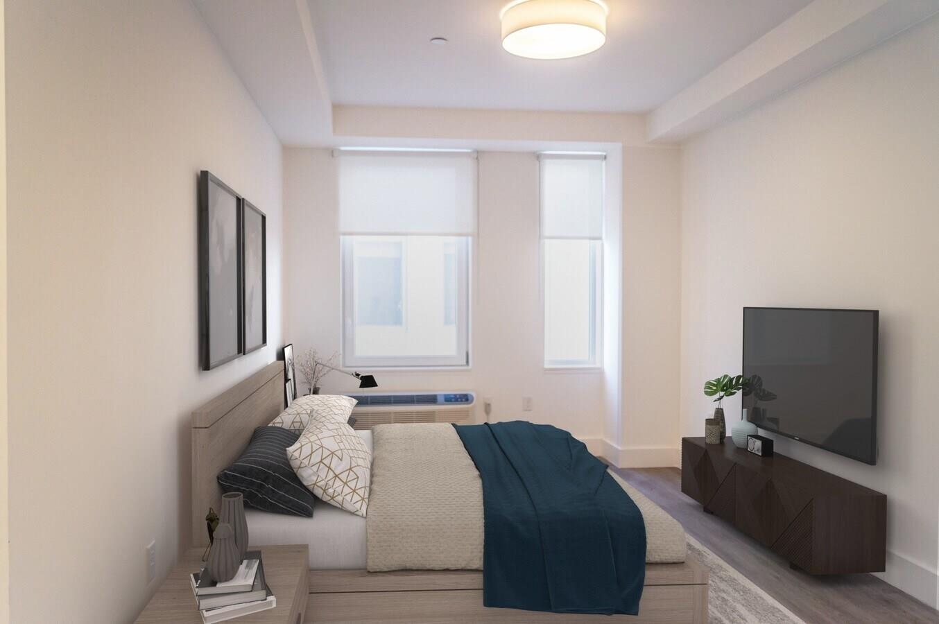 477 Broadway, Unit 409 Bayonne, NJ 07002 - Photo 2 of 19 a bedroom with a bed and flat screen tv