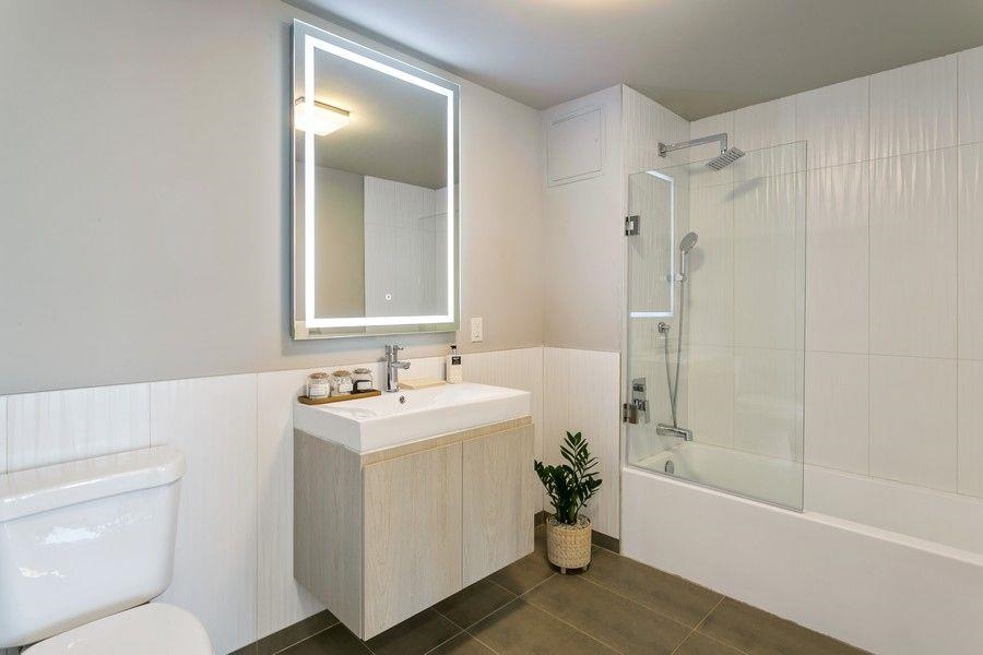 477 Broadway, Unit 409 Bayonne, NJ 07002 - Photo 3 of 19 a bathroom with a sink toilet vanity and shower