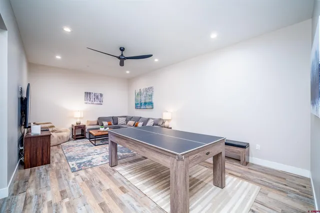 a living room with stainless steel appliances furniture a rug and a view of kitchen