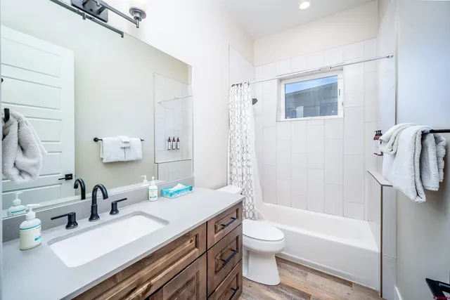 a bathroom with a granite countertop sink toilet and shower