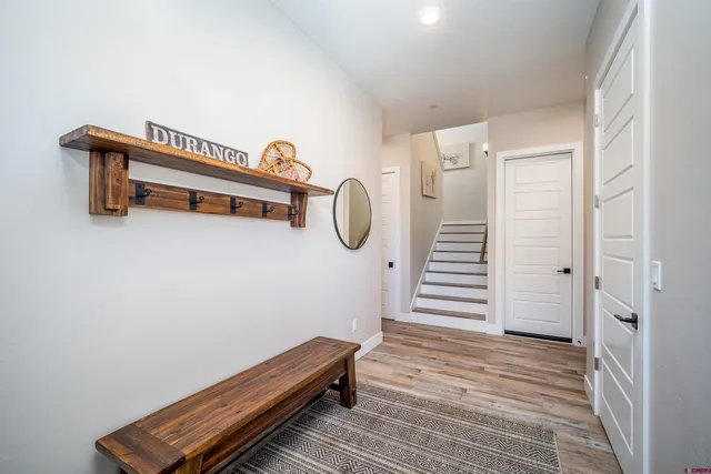 a hallway with stairs and wooden floor