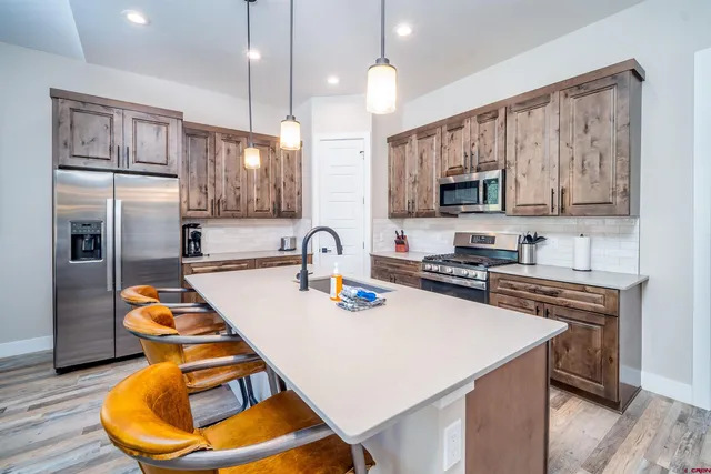 a kitchen with stainless steel appliances granite countertop a sink refrigerator and microwave