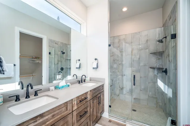 a bathroom with a granite countertop sink mirror and shower