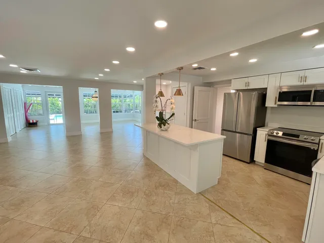 a large white kitchen with a large window
