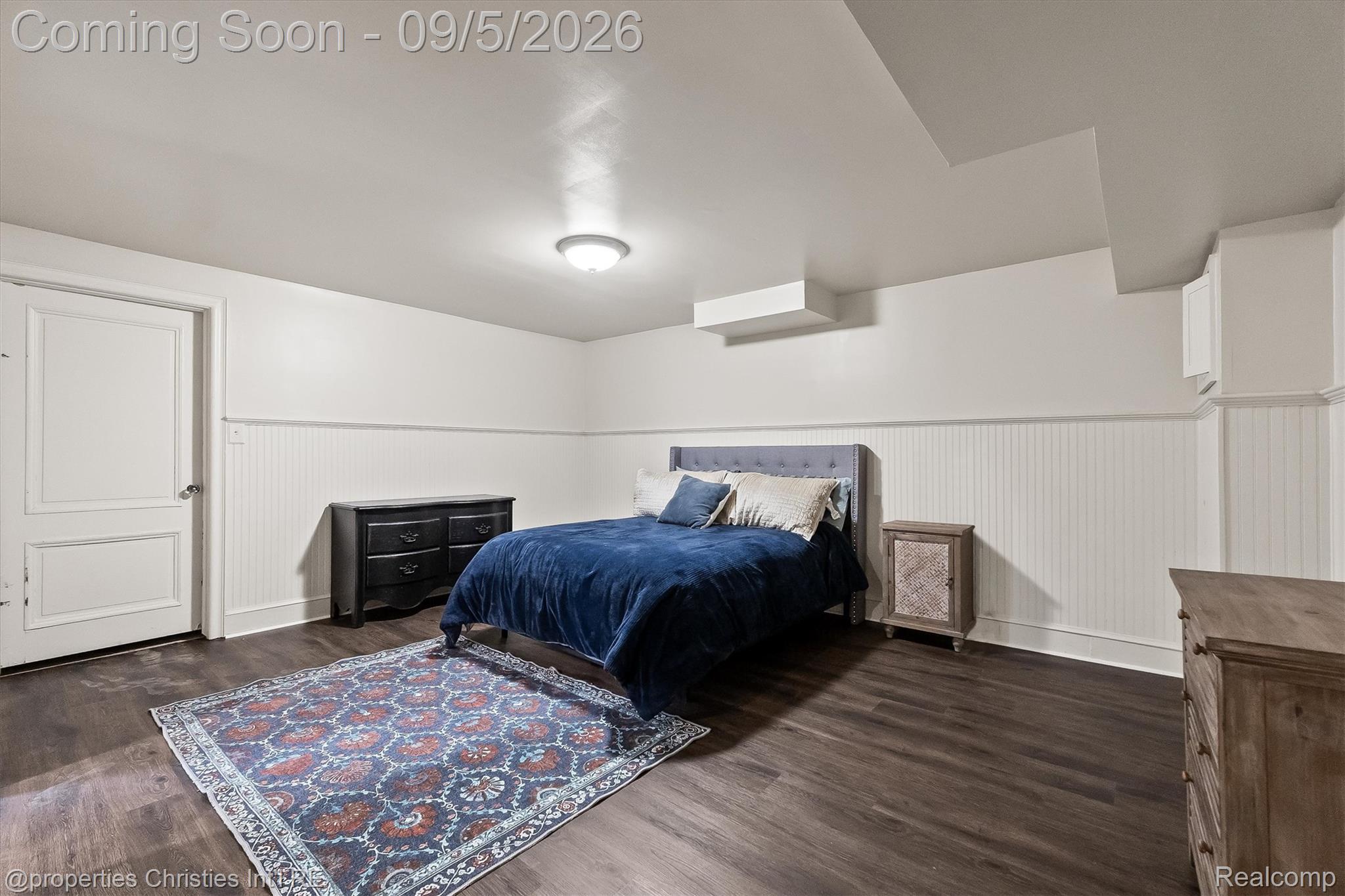 1540 Mill Race Road Rochester, MI 48306 - Photo 80 of 99 Wood-finish flooring, white beadboard wainscoting, white walls, and a ceiling light fixture