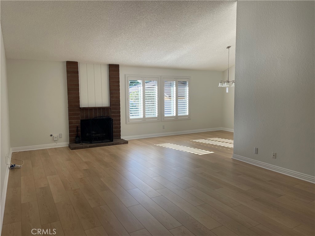601 Hunter Street Oceanside, CA 92058 - Photo 7 of 14 an empty room with wooden floor and a fireplace