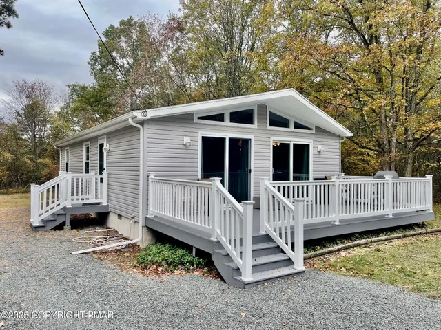 a view of a house with a yard and deck