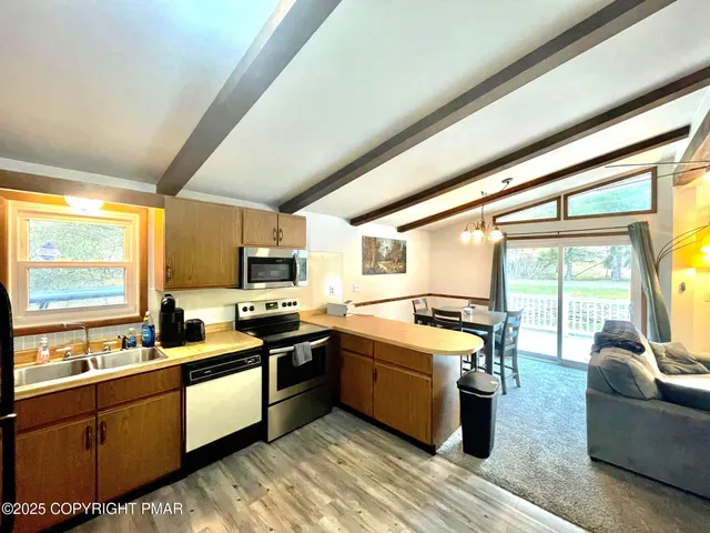 a kitchen that has a sink and chairs in it