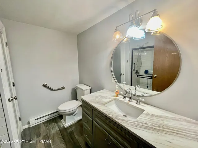 a bathroom with a granite countertop sink a toilet and a mirror