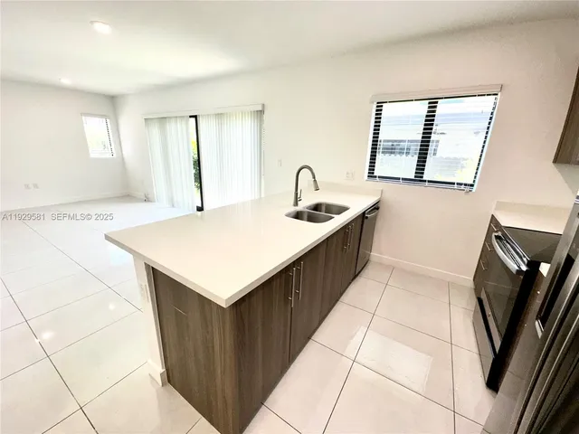 a kitchen that has a sink and a stove in it