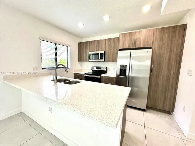 a large white kitchen with a large window