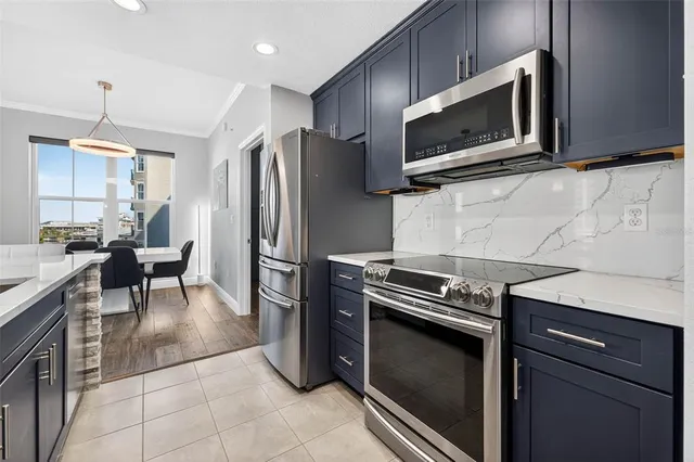 a kitchen with granite countertop a refrigerator stove and microwave