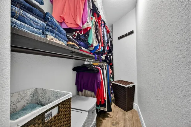 a view of walk in closet with clothes and shoes