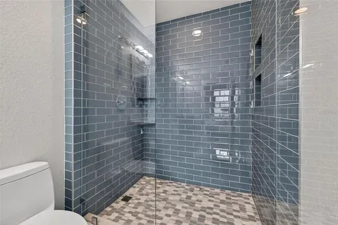 a bathroom with a toilet and a shower