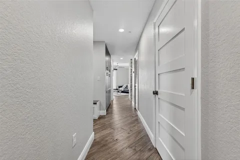 a view of a hallway with wooden floor