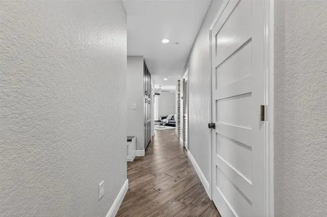 a view of a hallway with wooden floor