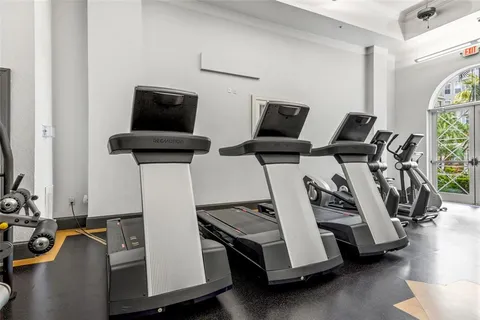 a room with gym equipment and wooden floor