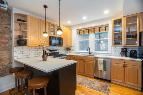a kitchen with a sink stove and wooden floor