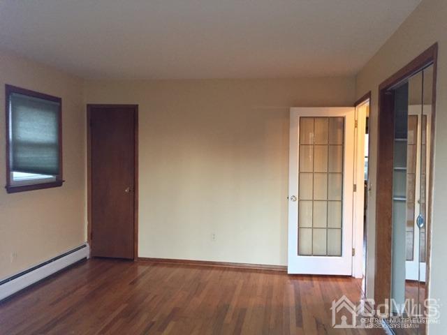 65 Tower Road Edison, NJ 08820 - Photo 7 of 14 an empty room with wooden floor and windows