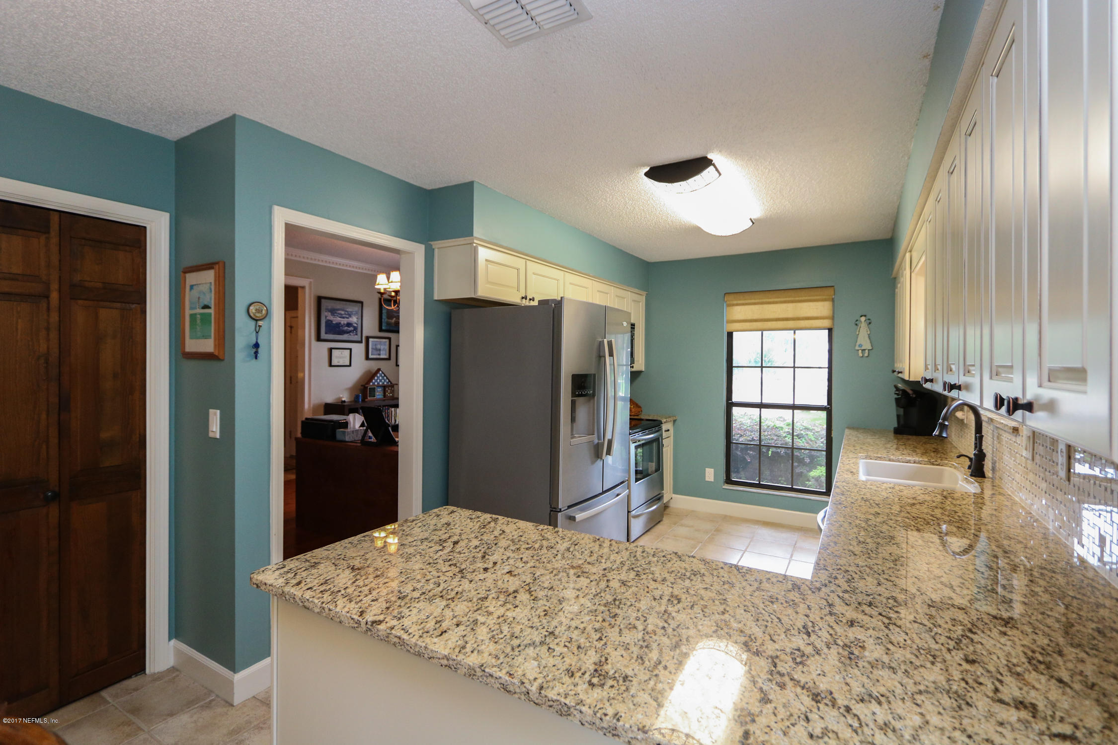 3141 Nautilus Road Middleburg, FL 32068 - Photo 11 of 43 a living room with stainless steel appliances kitchen island granite countertop furniture and a refrigerator