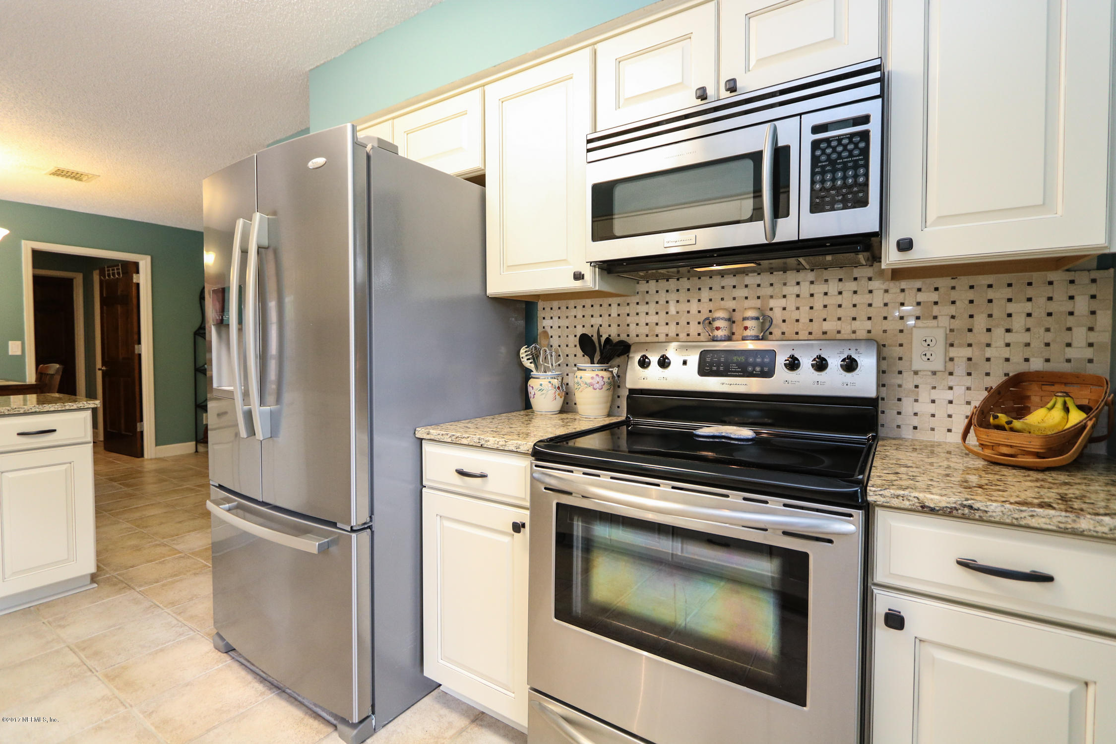 3141 Nautilus Road Middleburg, FL 32068 - Photo 13 of 43 a kitchen with stainless steel appliances granite countertop a stove microwave and refrigerator