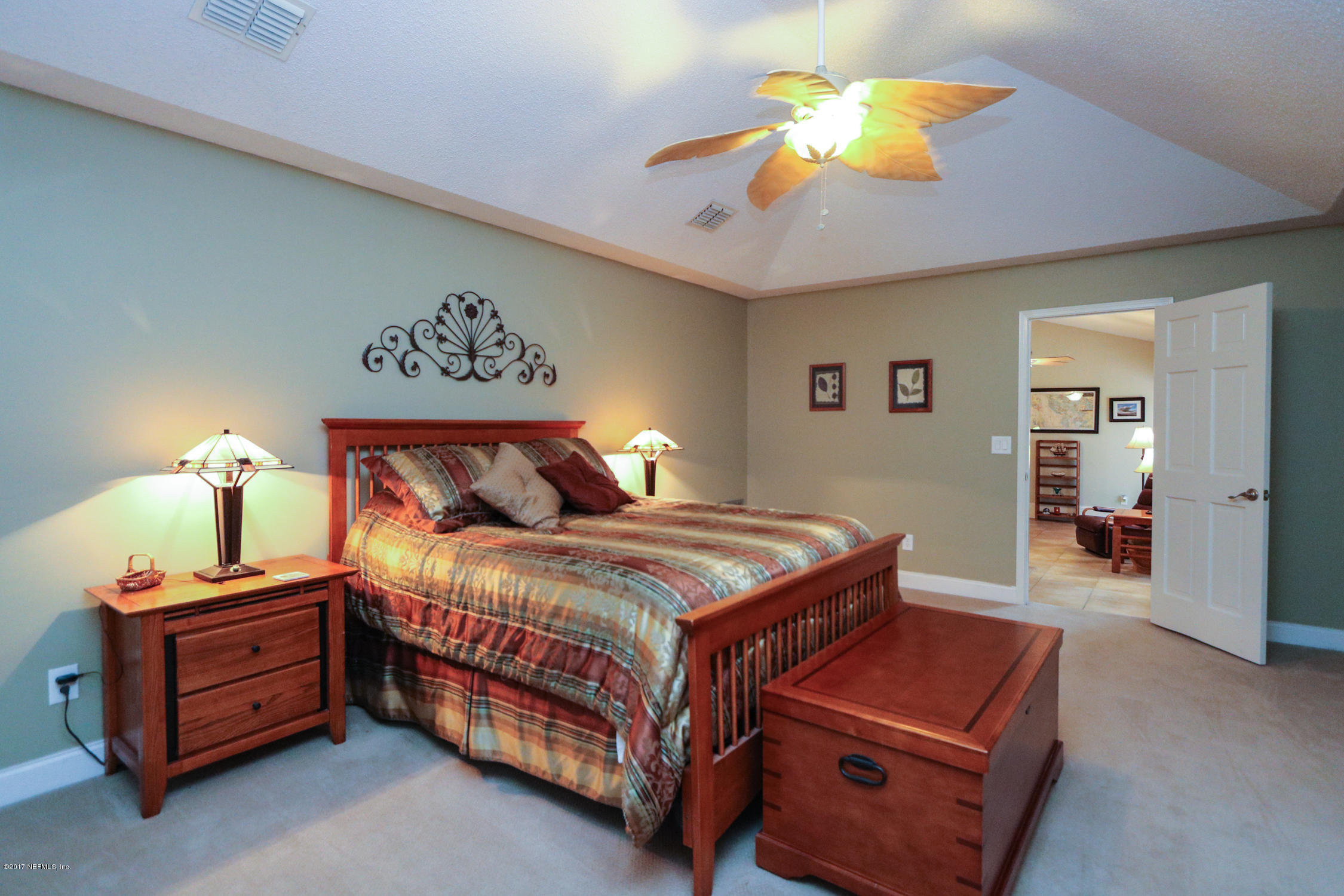 3141 Nautilus Road Middleburg, FL 32068 - Photo 23 of 43 a bedroom with a bed and a chandelier