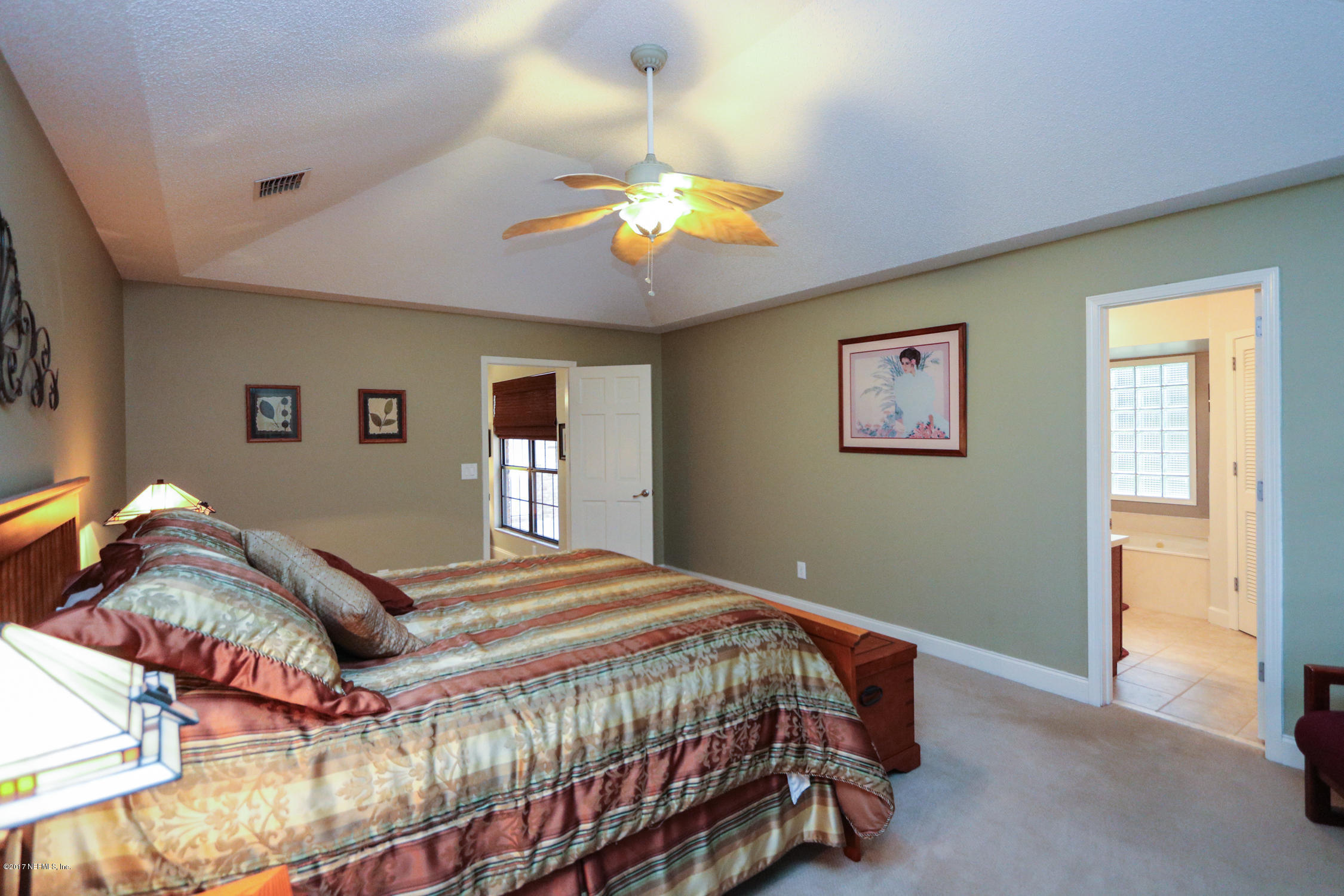 3141 Nautilus Road Middleburg, FL 32068 - Photo 24 of 43 a bedroom with a bed and a chandelier