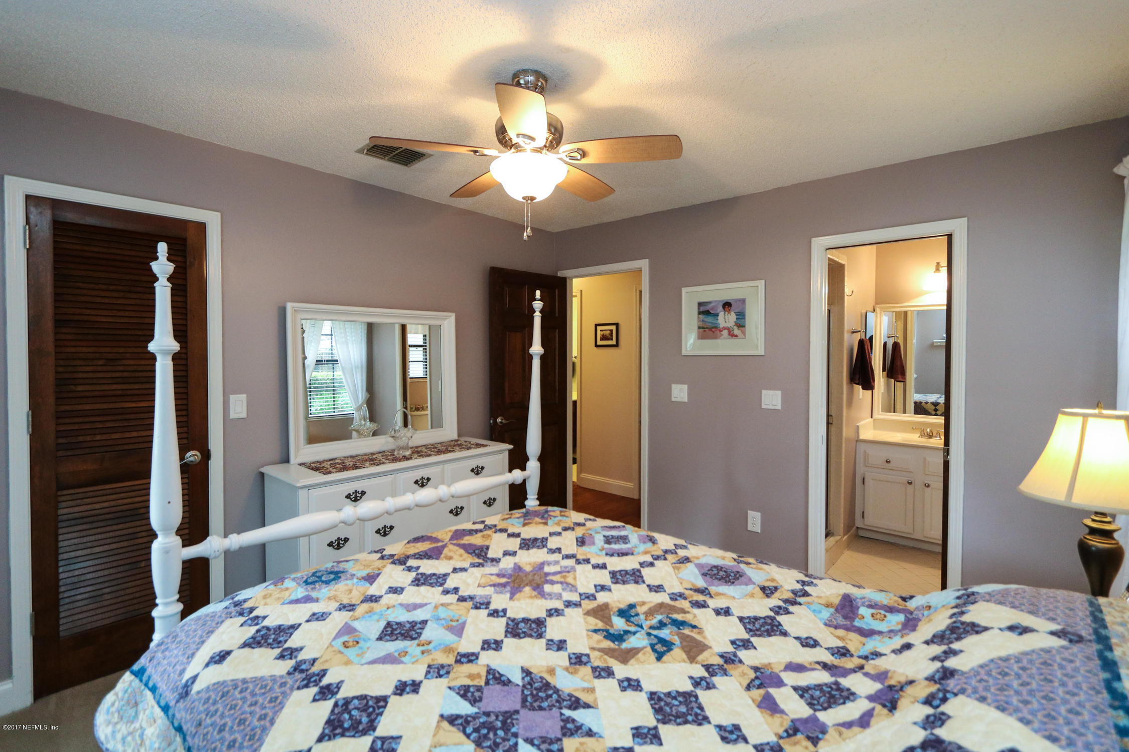 3141 Nautilus Road Middleburg, FL 32068 - Photo 29 of 43 a bedroom with a large bed and a chandelier