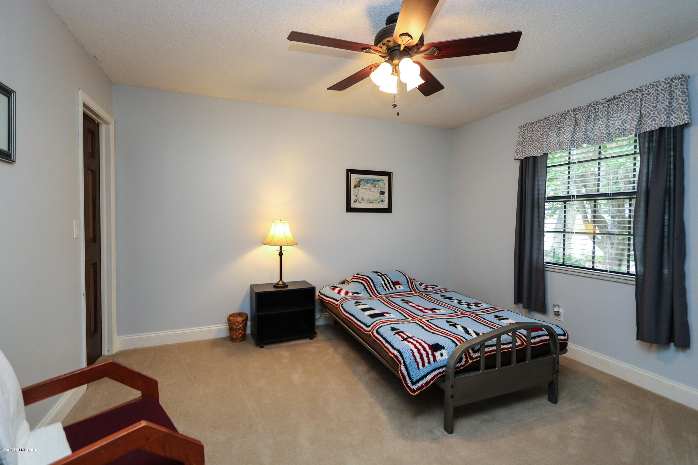 3141 Nautilus Road Middleburg, FL 32068 - Photo 31 of 43 a bedroom with a bed lamp and a window