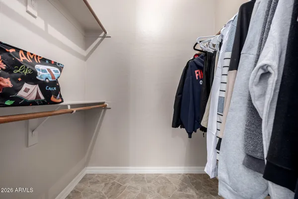 a view of walk in closet with clothes and shoes