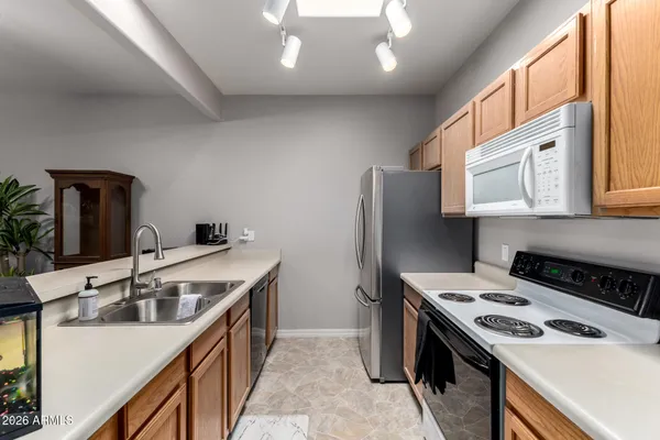 a kitchen that has a sink a stove and a refrigerator