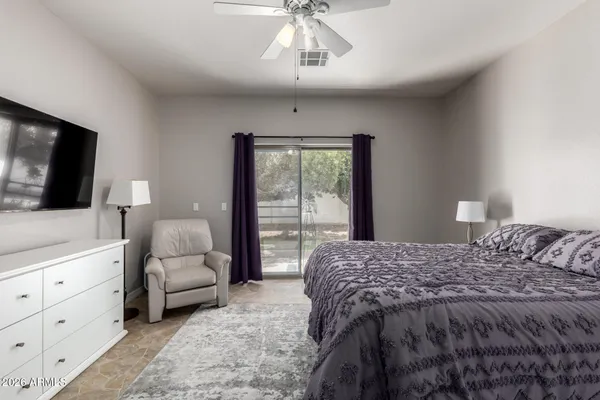 a bedroom with a large bed and a flat screen tv