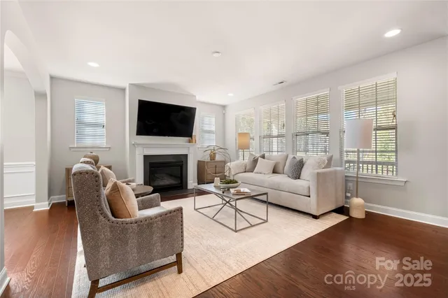 a living room with furniture a flat screen tv and a fireplace