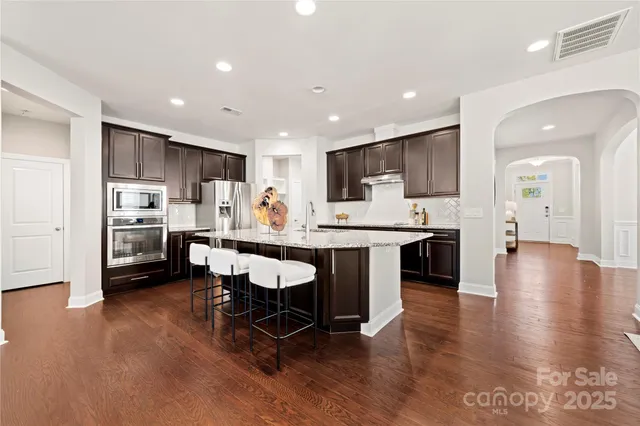 a kitchen with stainless steel appliances kitchen island granite countertop a sink and cabinets
