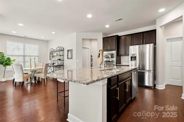 a kitchen with stainless steel appliances granite countertop a refrigerator and a stove top oven