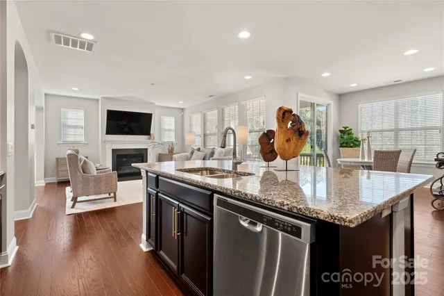 a kitchen with stainless steel appliances granite countertop a sink stove and wooden floor